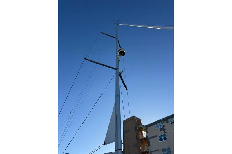 Genesis Yacht Photos Pics Mast of 2021 Jeanneau 54 sailboat against clear blue sky.