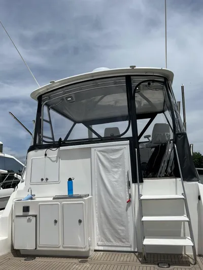 Necessity Yacht Photos Pics 2005 Albin 44 Command Bridge with enclosed cockpit and exterior stairs under a cloudy sky.