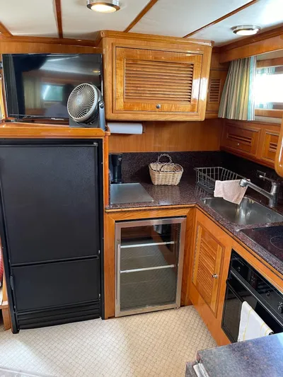 Necessity Yacht Photos Pics 2005 Albin 44 Command Bridge kitchen with wood cabinetry, appliances, and countertop.