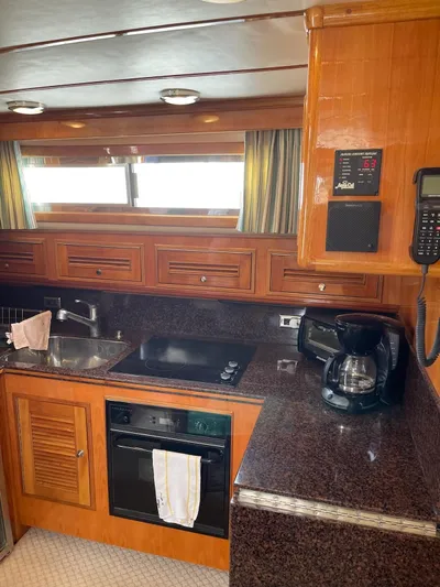 Necessity Yacht Photos Pics 2005 Albin 44 Command Bridge kitchen with wood cabinetry, sink, stove, and coffee maker.
