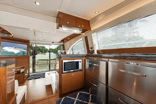 No Pods - V-drive Yacht Photos Pics Luxurious interior of 2015 Sea Ray 510 Fly yacht with modern kitchen and seating area.