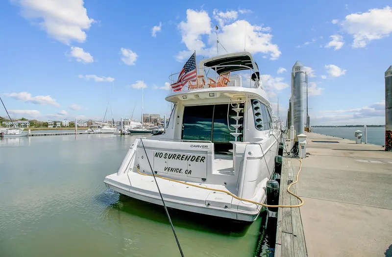 No Surrender Yacht Photos Pics 2000 Carver 530 Voyager Pilothouse docked at marina under blue sky.