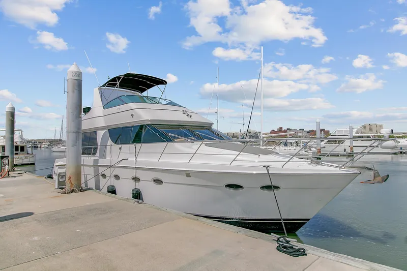 No Surrender Yacht Photos Pics 2000 Carver 530 Voyager Pilothouse yacht docked at marina under blue sky.