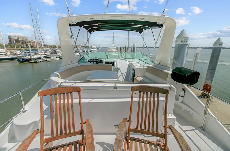 No Surrender Yacht Photos Pics 2000 Carver 530 Voyager Pilothouse yacht with wooden chairs on deck, docked at marina.