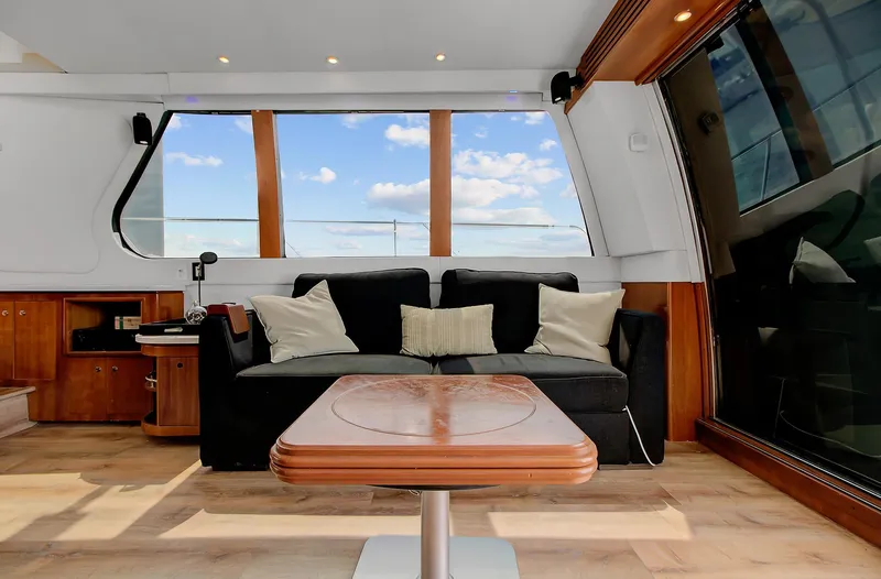 No Surrender Yacht Photos Pics Luxurious interior of 2000 Carver 530 Voyager Pilothouse with sofa and wooden table.