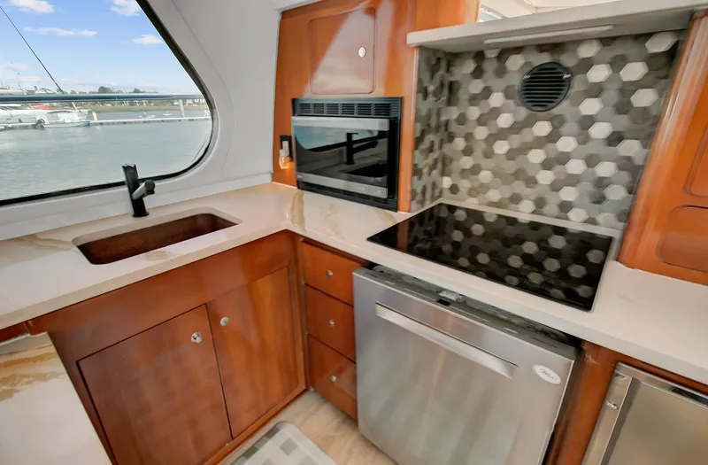 No Surrender Yacht Photos Pics Modern kitchen in a 2000 Carver 530 Voyager Pilothouse yacht with sleek appliances and hexagonal backsplash.