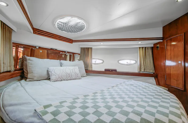 No Surrender Yacht Photos Pics Luxurious bedroom interior of 2000 Carver 530 Voyager Pilothouse yacht with elegant wood finish.