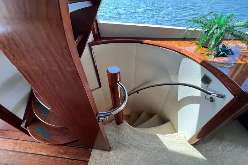  Yacht Photos Pics Luxurious 2007 Lazzara 68 yacht interior with elegant spiral staircase and wooden accents.