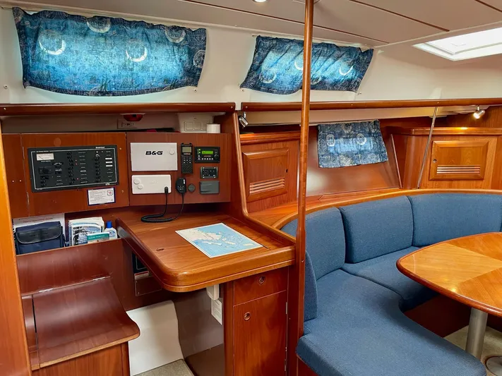 Oasis Yacht Photos Pics 2004 Beneteau Oceanis 393 interior with navigation station and blue seating.