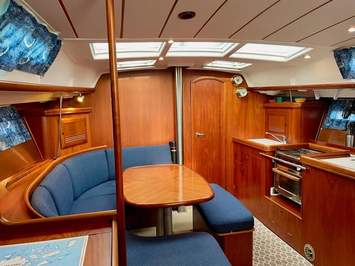 Oasis Yacht Photos Pics Interior of 2004 Beneteau Oceanis 393 sailboat with wood finish and blue upholstery.
