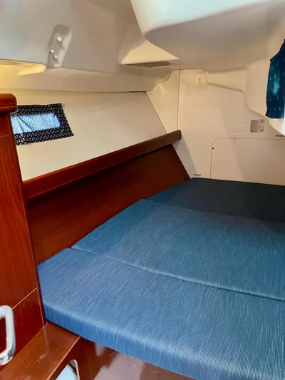 Oasis Yacht Photos Pics 2004 Beneteau Oceanis 393 cabin interior with blue bedding and wooden accents.