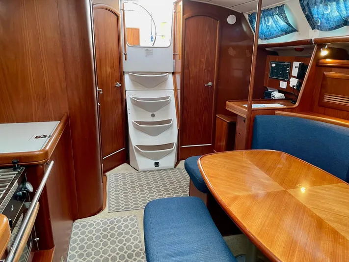 Oasis Yacht Photos Pics Interior of 2004 Beneteau Oceanis 393 sailboat with wood finish and blue upholstery.