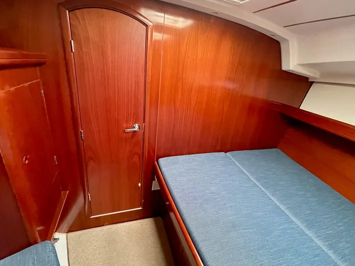 Oasis Yacht Photos Pics 2004 Beneteau Oceanis 393 cabin with wooden interior and blue bedding.