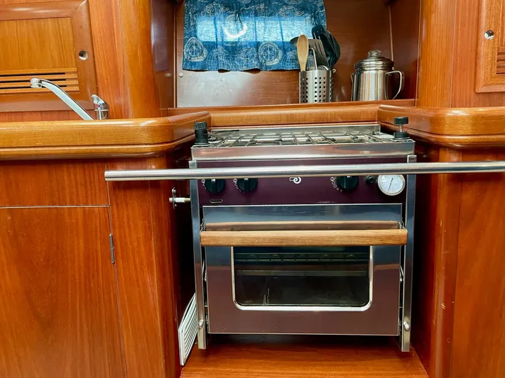 Oasis Yacht Photos Pics Wooden kitchen interior with stove on 2004 Beneteau Oceanis 393 sailboat.