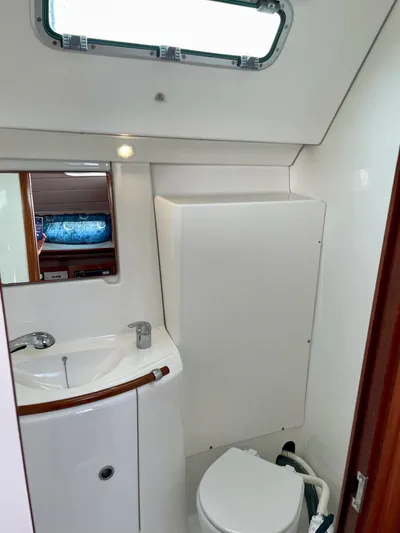 Oasis Yacht Photos Pics 2004 Beneteau Oceanis 393 yacht bathroom with sink, mirror, and toilet.