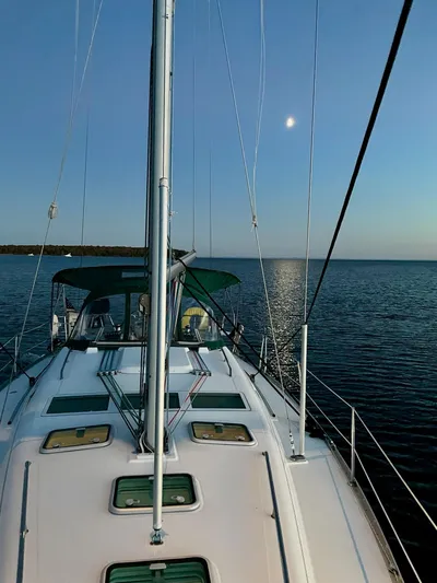Oasis Yacht Photos Pics Beneteau Oceanis 393 sailboat on calm waters at sunset, 2004 model.