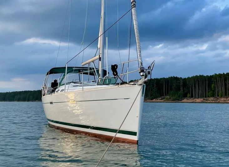 Oasis Yacht Photos Pics 2004 Beneteau Oceanis 393 sailboat anchored on calm water under cloudy sky.