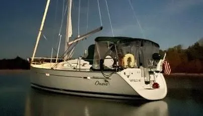 Oasis Yacht Photos Pics 2004 Beneteau Oceanis 393 sailboat anchored on calm water, featuring sleek design and sails.