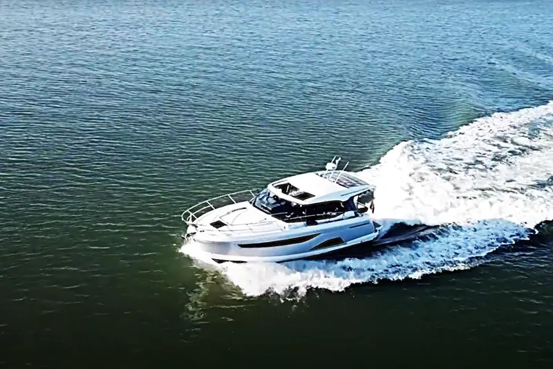 #boatshowspecial Yacht Photos Pics 2023 Bavaria R40 Coupe cruising on open water, creating a dynamic wake.