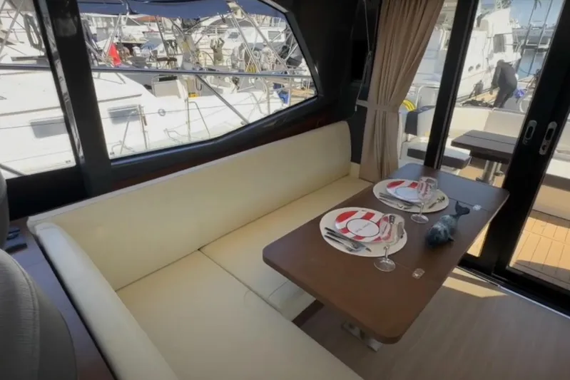 #boatshowspecial Yacht Photos Pics Interior of 2023 Bavaria R40 Coupe yacht with elegant dining setup and marina view.