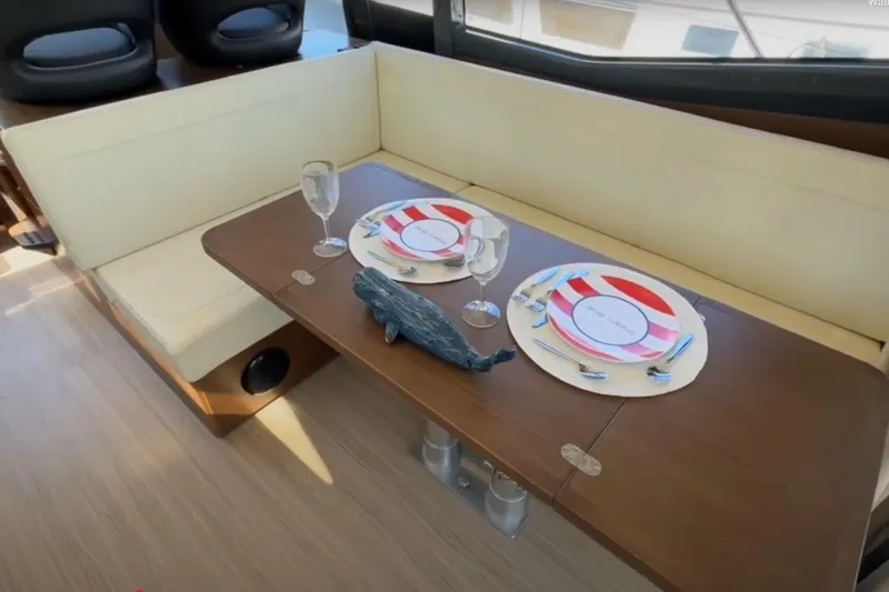 #boatshowspecial Yacht Photos Pics Interior of 2023 Bavaria R40 Coupe with elegant dining setup on wooden table.