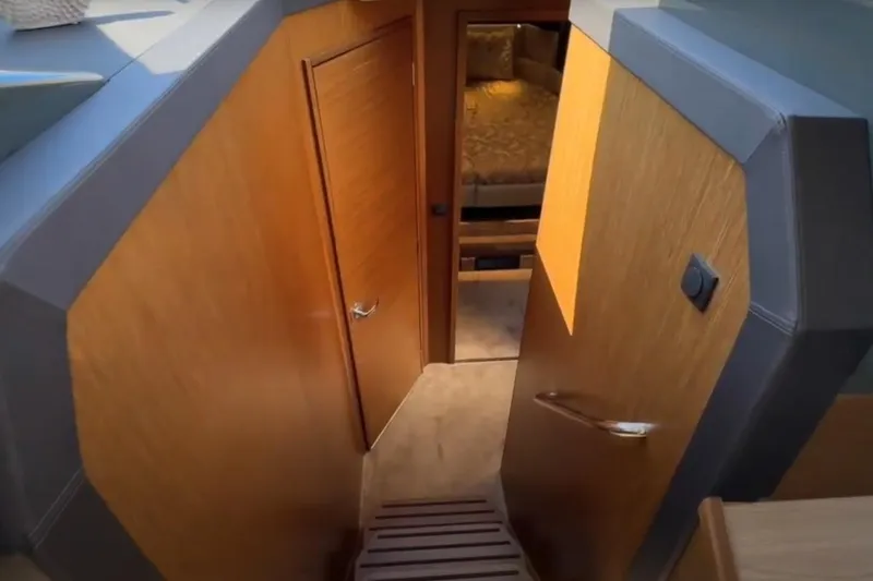 #boatshowspecial Yacht Photos Pics Interior view of 2023 Bavaria R40 Coupe, featuring wooden doors and cozy cabin space.