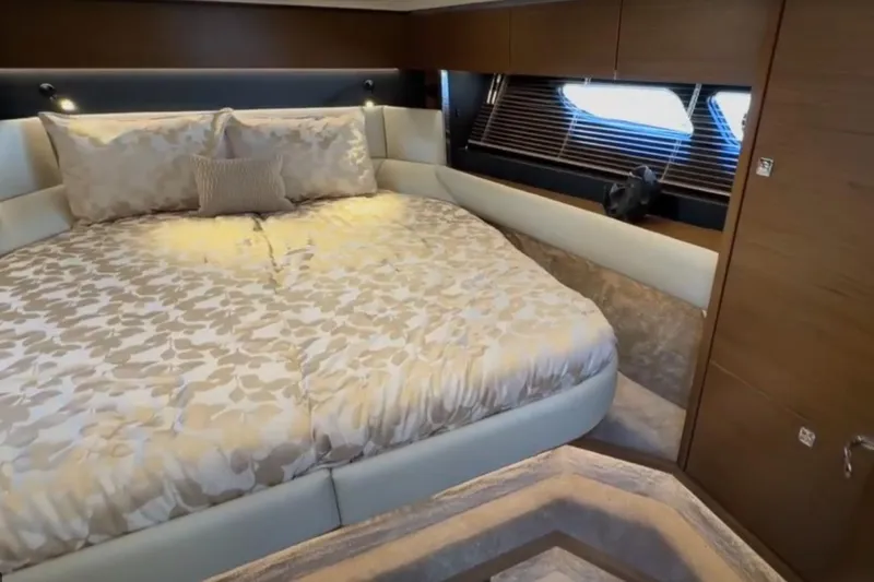#boatshowspecial Yacht Photos Pics Luxurious bedroom interior of 2023 Bavaria R40 Coupe yacht with elegant bedding and wood accents.