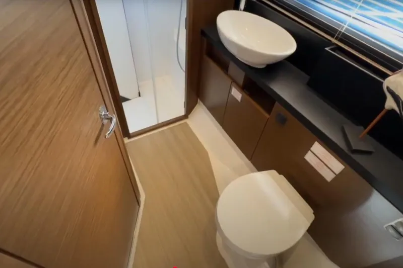 #boatshowspecial Yacht Photos Pics 2023 Bavaria R40 Coupe bathroom with modern fixtures and wooden accents.