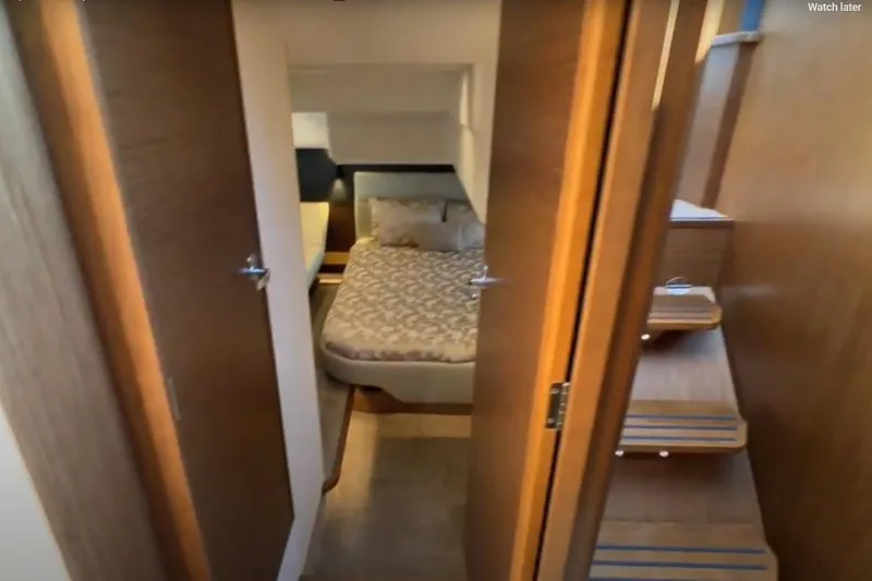 #boatshowspecial Yacht Photos Pics Interior of 2023 Bavaria R40 Coupe, featuring a cozy bedroom and wooden stairs.