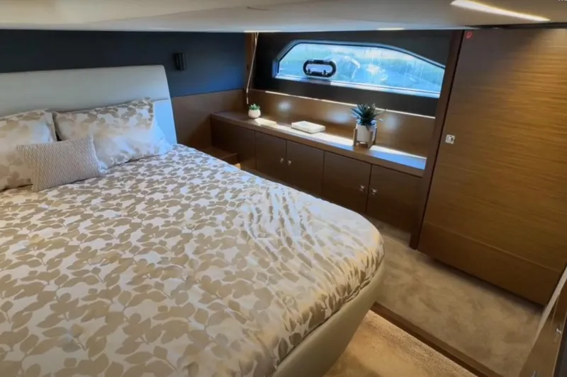 #boatshowspecial Yacht Photos Pics Luxurious bedroom interior of 2023 Bavaria R40 Coupe yacht with elegant bedding and wood accents.