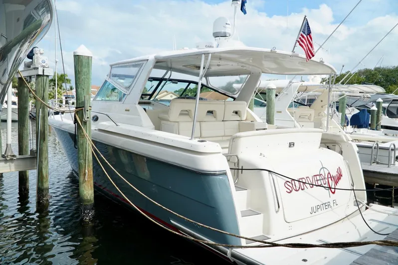 Survey Cruise Yacht Photos Pics 1998 Tiara Yachts 4000 Express docked, featuring sleek design and American flag.