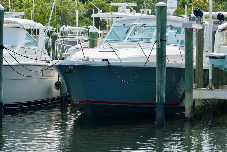 Survey Cruise Yacht Photos Pics 1998 Tiara Yachts 4000 Express docked at marina, surrounded by other boats.