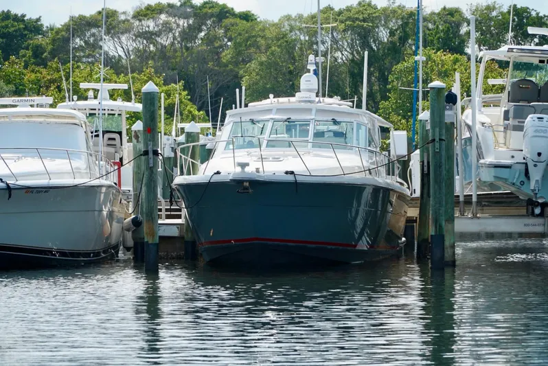 Survey Cruise Yacht Photos Pics 1998 Tiara Yachts 4000 Express docked at a marina, surrounded by other boats.