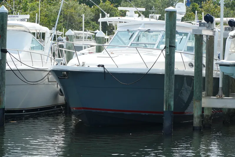Survey Cruise Yacht Photos Pics 1998 Tiara Yachts 4000 Express docked at marina, surrounded by other boats.
