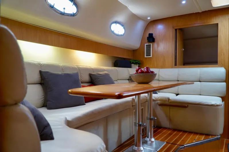 Survey Cruise Yacht Photos Pics Luxurious interior of 1998 Tiara Yachts 4000 Express with plush seating and wooden table.