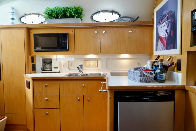 Survey Cruise Yacht Photos Pics 1998 Tiara Yachts 4000 Express kitchen with wood cabinets, microwave, and mini fridge.