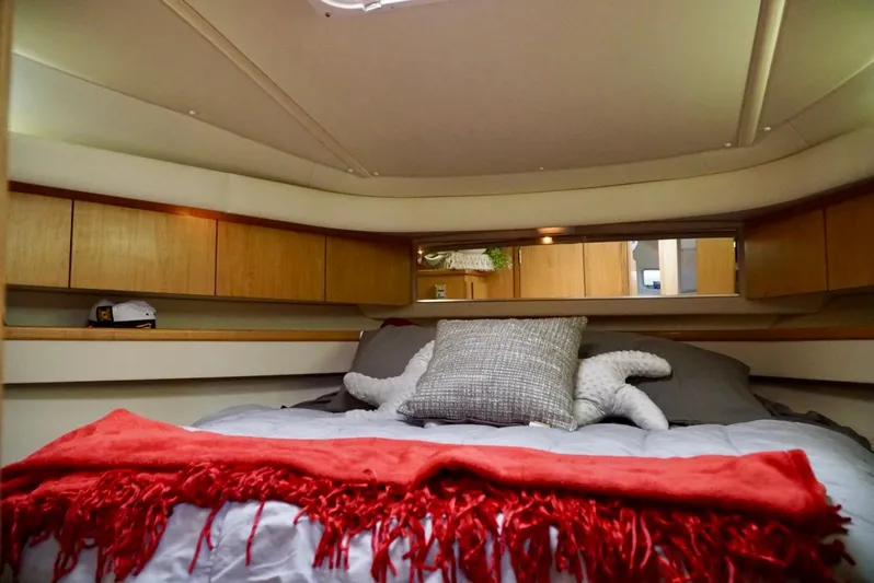 Survey Cruise Yacht Photos Pics Cozy cabin interior of 1998 Tiara Yachts 4000 Express with red blanket and pillows.