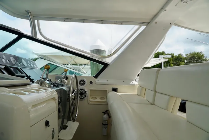 Survey Cruise Yacht Photos Pics 1998 Tiara Yachts 4000 Express interior with helm, steering wheel, and white seating.