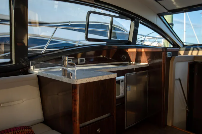 Logan Yacht Photos Pics Interior of 2018 Sea Ray Sundancer 400 yacht, featuring a modern kitchenette and seating area.