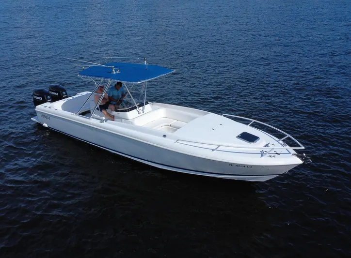  Yacht Photos Pics 2002 Intrepid 323 Cuddy boat with blue canopy on open water.