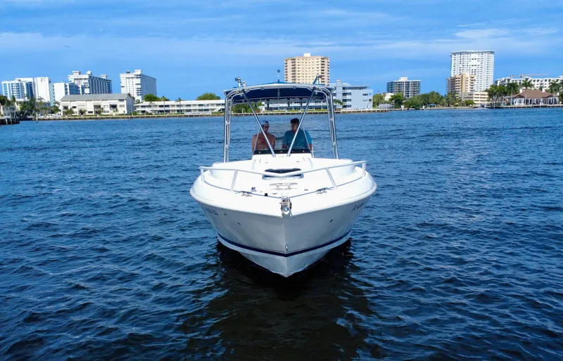  Yacht Photos Pics 2002 Intrepid 323 Cuddy boat on water with city skyline in background.