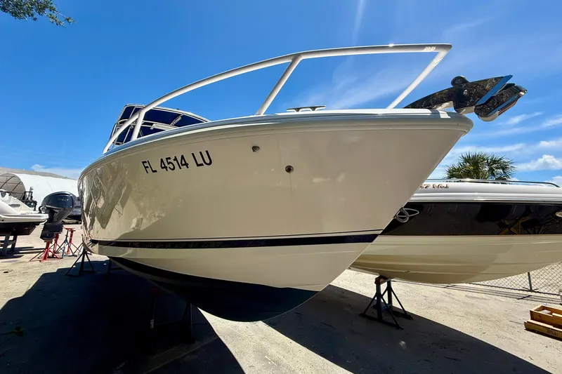  Yacht Photos Pics 2002 Intrepid 323 Cuddy boat on dry dock under clear blue sky.