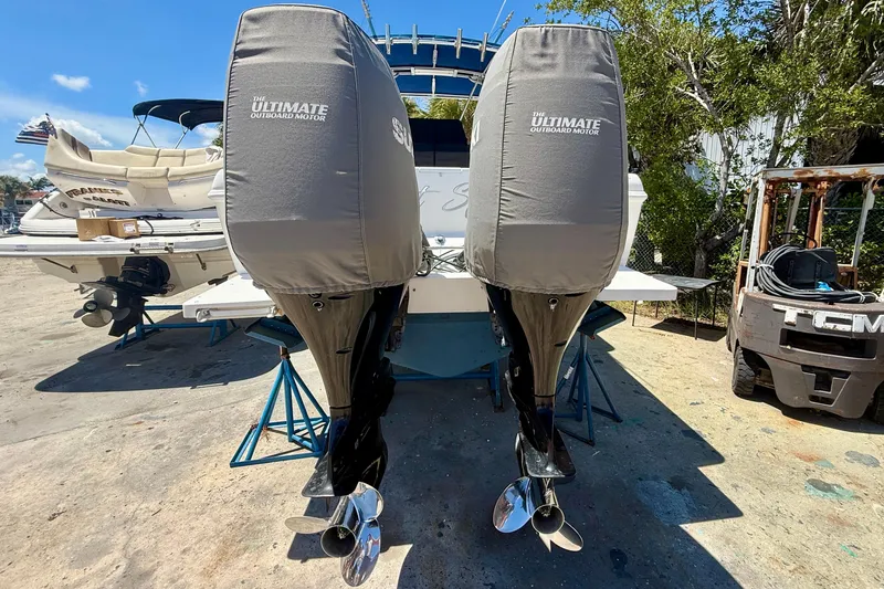  Yacht Photos Pics 2002 Intrepid 323 Cuddy with covered outboard motors on a sunny day.