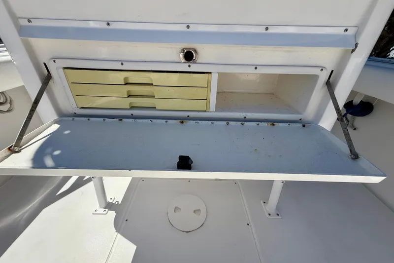  Yacht Photos Pics Storage compartment on a 2002 Intrepid 323 Cuddy boat, featuring drawers and open space.