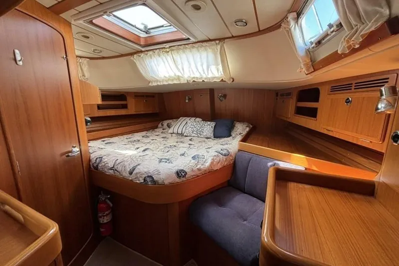 Cygnus Yacht Photos Pics Cozy cabin interior of 2000 Hallberg-Rassy 46 yacht with wood finish and skylight.