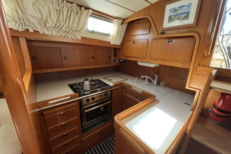 Cygnus Yacht Photos Pics Hallberg-Rassy 46 yacht kitchen, 2000 model, featuring wooden cabinetry and modern appliances.