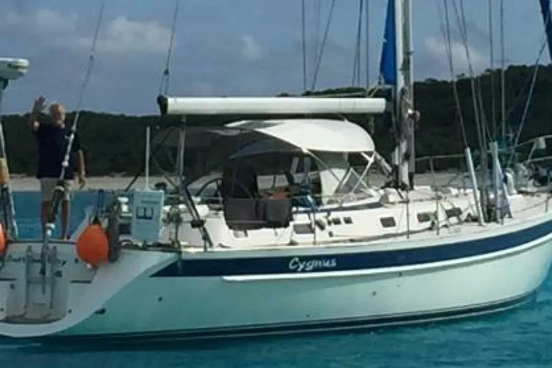 Cygnus Yacht Photos Pics Sailing yacht Hallberg-Rassy 46, 2000 model, anchored in clear blue waters.