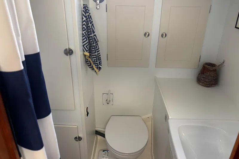 Cygnus Yacht Photos Pics Hallberg-Rassy 46 yacht bathroom, featuring toilet, sink, and storage cabinets, 2000 model.
