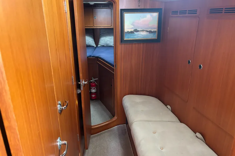 Cygnus Yacht Photos Pics Hallberg-Rassy 46 yacht interior, featuring wooden paneling, a cozy cabin, and a framed painting.