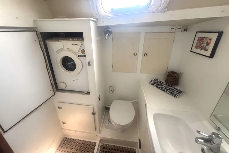 Cygnus Yacht Photos Pics Bathroom interior of 2000 Hallberg-Rassy 46 yacht with washer, toilet, and sink.